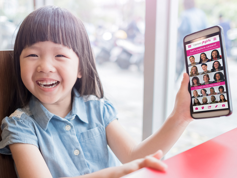 mobile app screen showing on a phone being held by a girl seated at a table